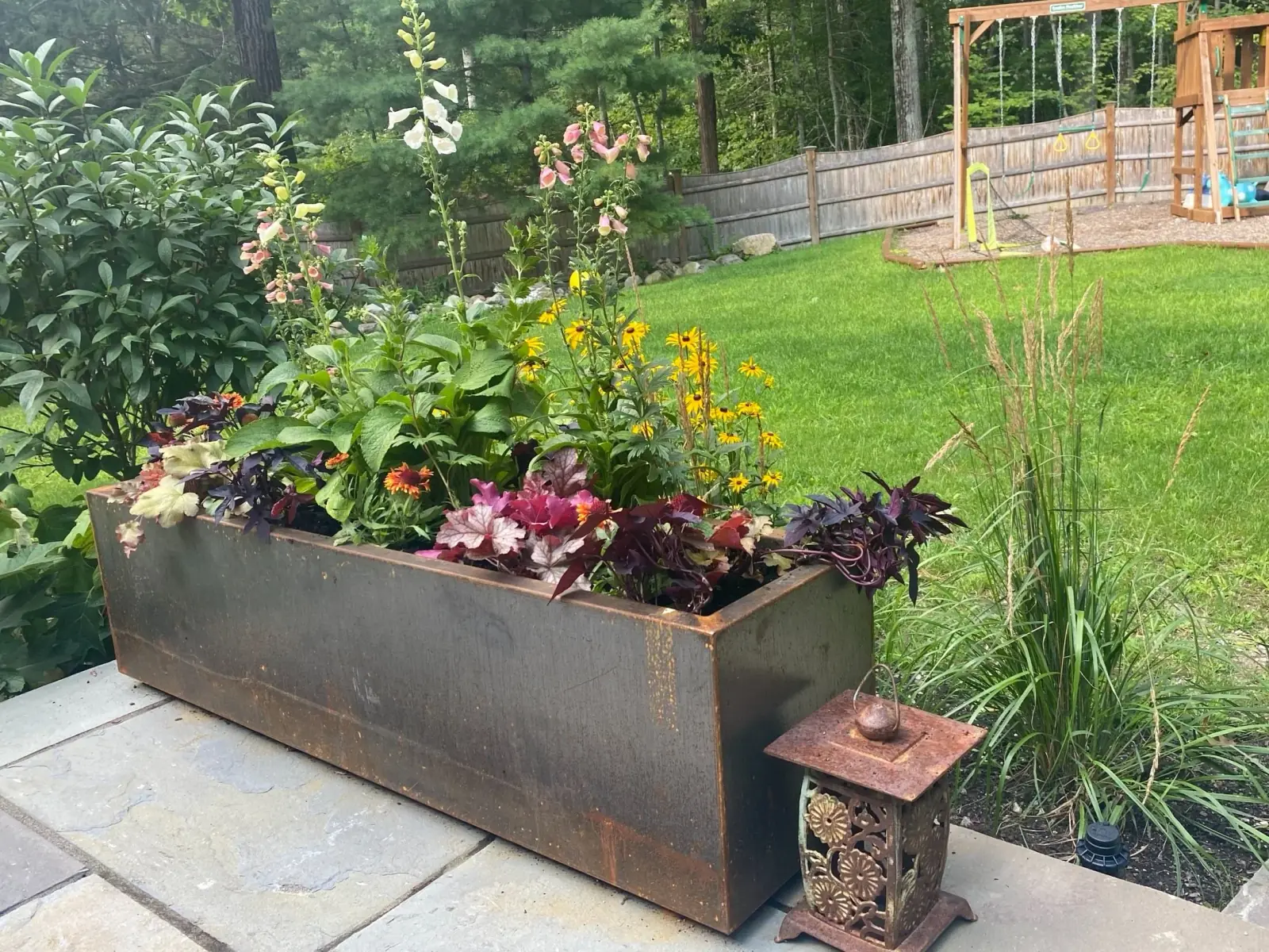 Rusted-bronze trough planter with poppies and violas